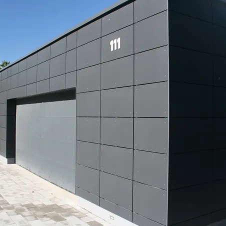 Bardage d'un garage d'une maison construit avec des panneaux autoclavés Swisspearl®