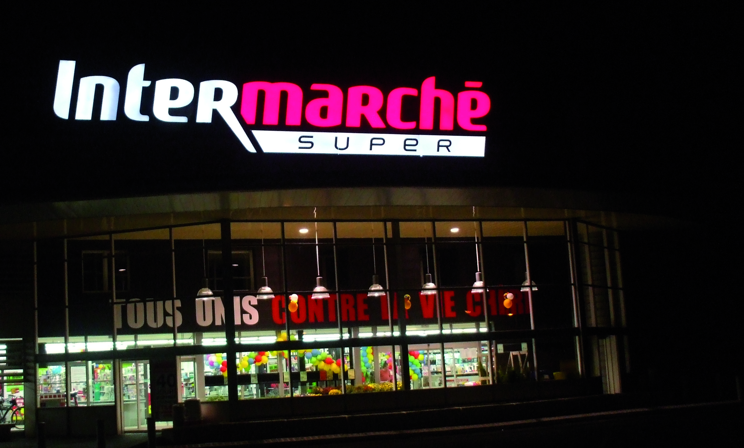 Enseigne illuminée blanche et rouge pour le supermarché Intermarché avec du PMMA Black and White vue de nuit