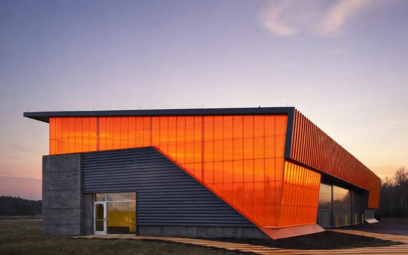 Bardage d'un bâtiment sportif en polycarbonate emboîtable arcoWall® 5613 orange